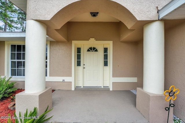 doorway to property featuring stucco siding