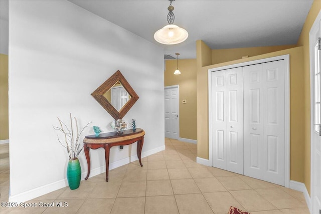 interior space with light tile patterned floors and baseboards