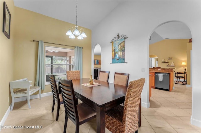 dining space featuring light tile patterned floors, baseboards, arched walkways, and a notable chandelier