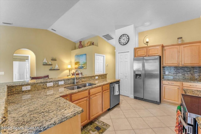 kitchen with stainless steel appliances, light stone counters, a sink, and visible vents