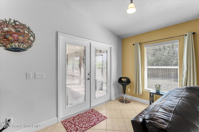 doorway with french doors, light tile patterned floors, vaulted ceiling, a textured ceiling, and baseboards