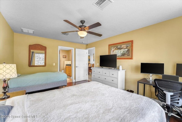 bedroom featuring a ceiling fan, visible vents, and a textured ceiling