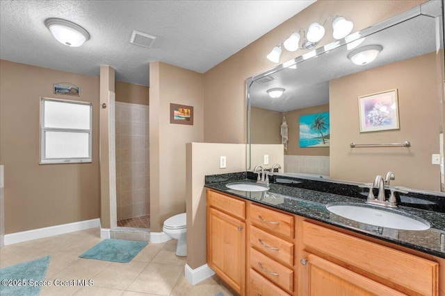 bathroom featuring a walk in shower, double vanity, tile patterned flooring, and a sink