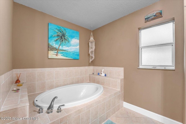 full bathroom featuring tile patterned flooring, a textured ceiling, baseboards, and a bath