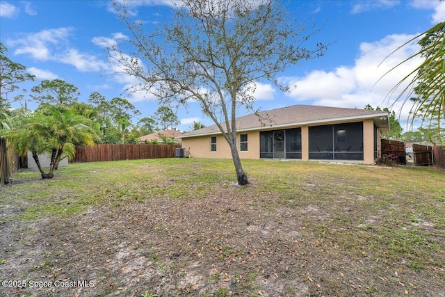 view of yard with a sunroom, a fenced backyard, and central AC unit