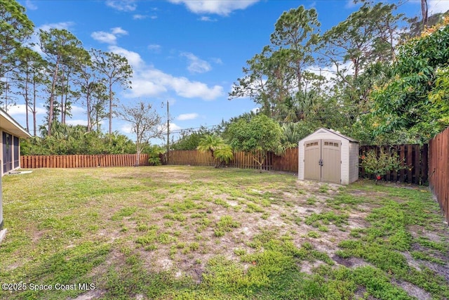 view of yard featuring an outbuilding, a shed, and a fenced backyard