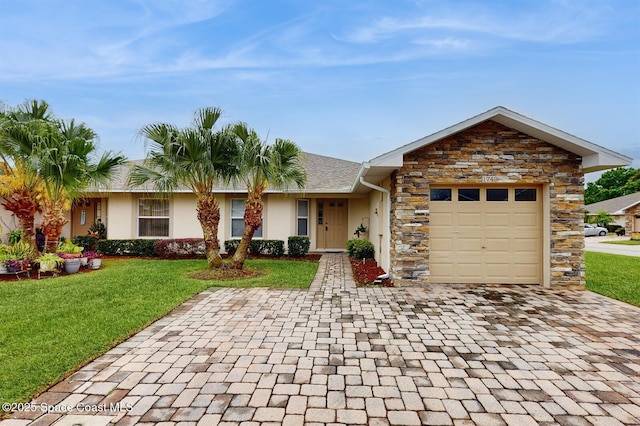 ranch-style home with a garage, stone siding, a front lawn, and stucco siding