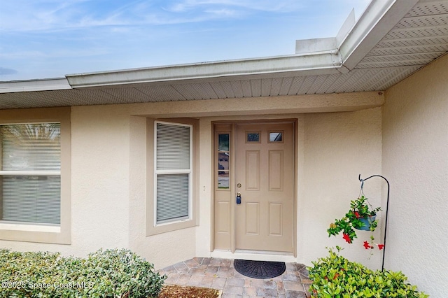 entrance to property featuring stucco siding