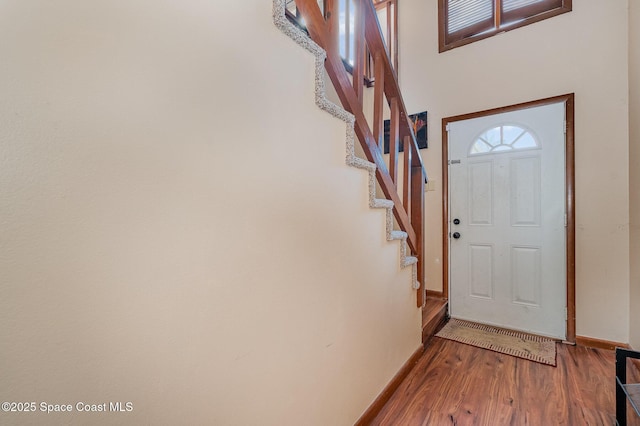 foyer entrance with a wealth of natural light, baseboards, and wood finished floors