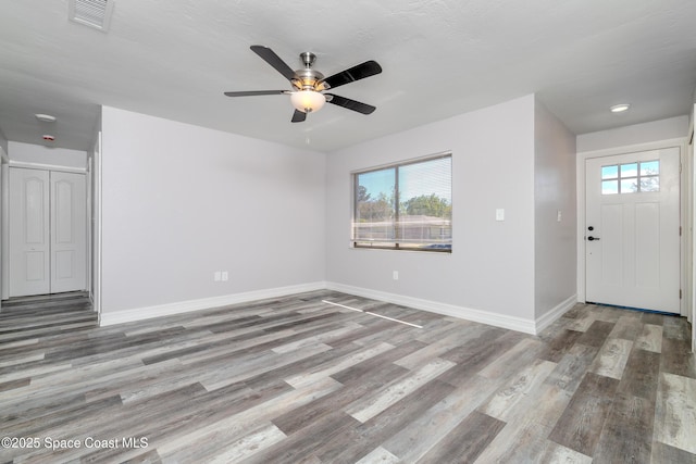 foyer featuring a healthy amount of sunlight, light wood finished floors, visible vents, and baseboards