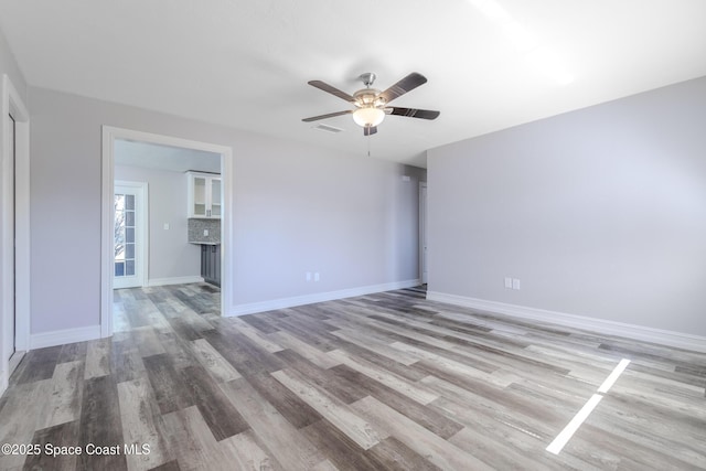 unfurnished bedroom with light wood-type flooring, visible vents, ceiling fan, and baseboards