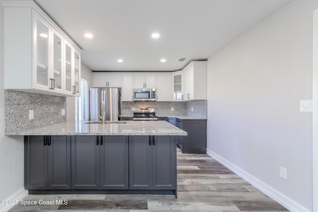 kitchen featuring glass insert cabinets, white cabinetry, and appliances with stainless steel finishes