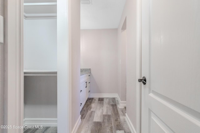 interior space featuring light wood-style floors, visible vents, and baseboards