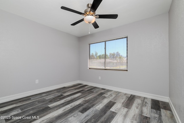 spare room featuring dark wood finished floors, a ceiling fan, and baseboards