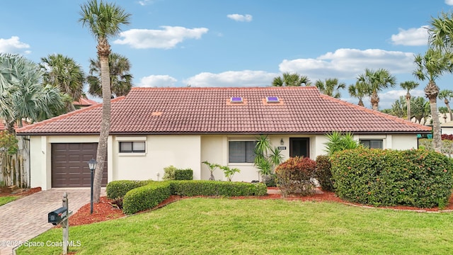 mediterranean / spanish-style house with stucco siding, a front lawn, a tile roof, decorative driveway, and a garage