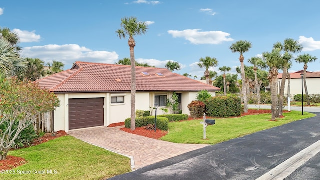 view of front facade with a front yard, decorative driveway, an attached garage, and stucco siding