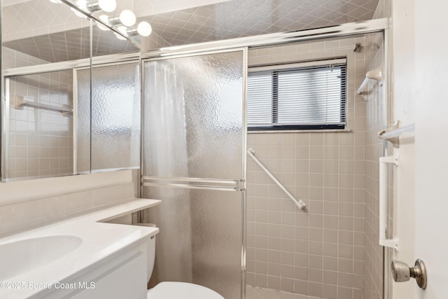 full bathroom with a shower stall, toilet, and vanity