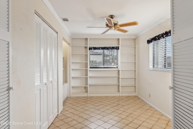 interior space featuring visible vents, built in shelves, ornamental molding, baseboards, and ceiling fan