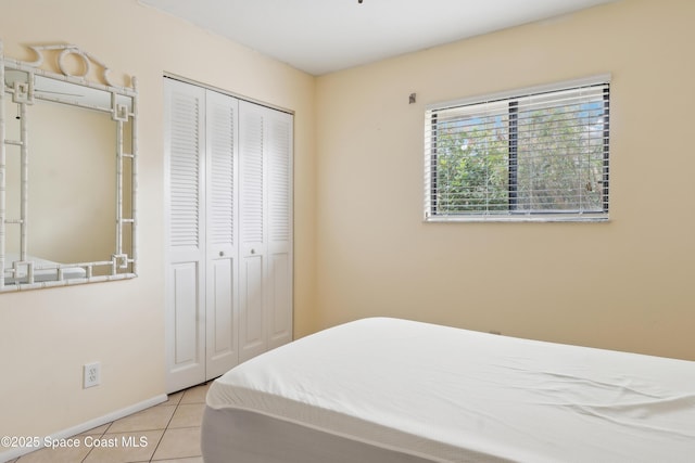 bedroom with a closet, baseboards, and tile patterned flooring