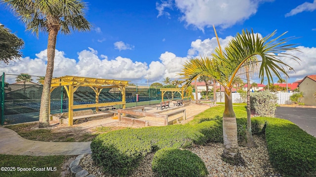 view of property's community featuring fence and a pergola