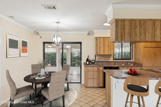 kitchen with dark countertops, visible vents, a chandelier, and ornamental molding