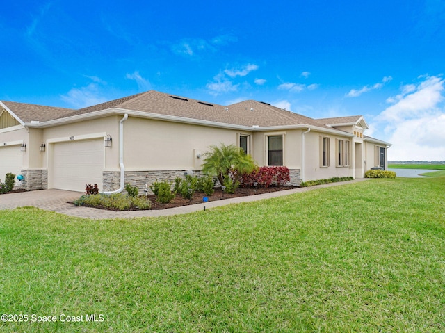 view of front of house featuring decorative driveway, stucco siding, an attached garage, stone siding, and a front lawn