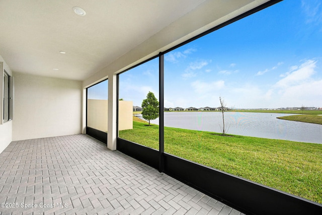 unfurnished sunroom featuring a water view