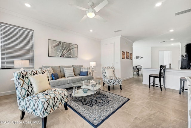 living room with baseboards, visible vents, and ornamental molding