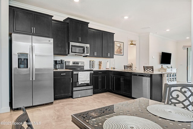 kitchen with ornamental molding, stainless steel appliances, dark cabinetry, and light countertops