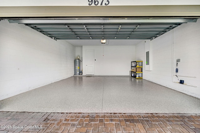 garage featuring water heater, electric panel, and a garage door opener