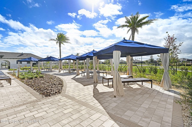 view of property's community with fence, a gazebo, and a patio