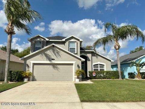 traditional-style house with stucco siding, a front lawn, concrete driveway, and an attached garage