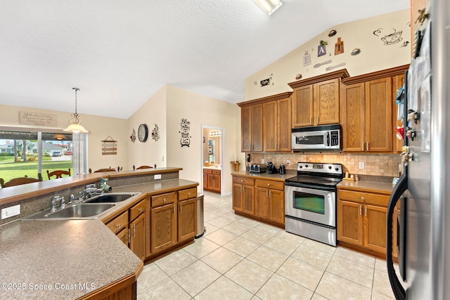 kitchen with dark countertops, pendant lighting, stainless steel appliances, and a sink