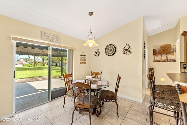 dining space with lofted ceiling, light tile patterned floors, and baseboards