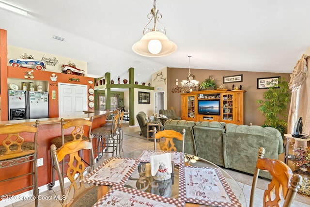 dining room with lofted ceiling, light tile patterned floors, visible vents, and a notable chandelier