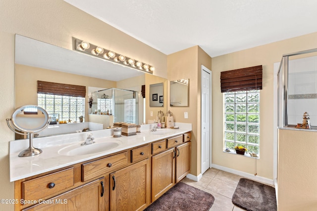 bathroom with double vanity, tile patterned flooring, a sink, and a shower stall