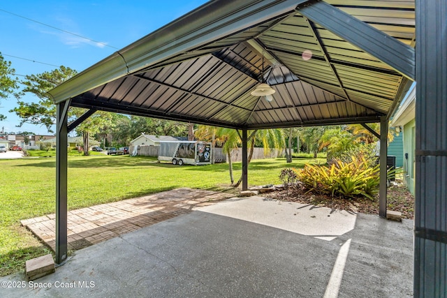 view of car parking with a carport, fence, and a gazebo