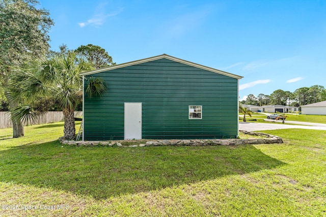 view of property exterior with a lawn and fence