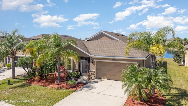 view of front of home with a shingled roof, concrete driveway, an attached garage, a front lawn, and stucco siding