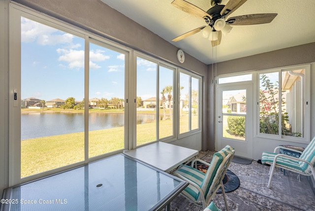 sunroom with a water view and ceiling fan