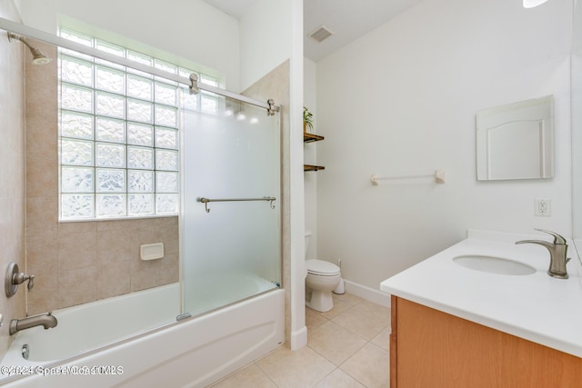 bathroom with toilet, bath / shower combo with glass door, tile patterned flooring, and a wealth of natural light