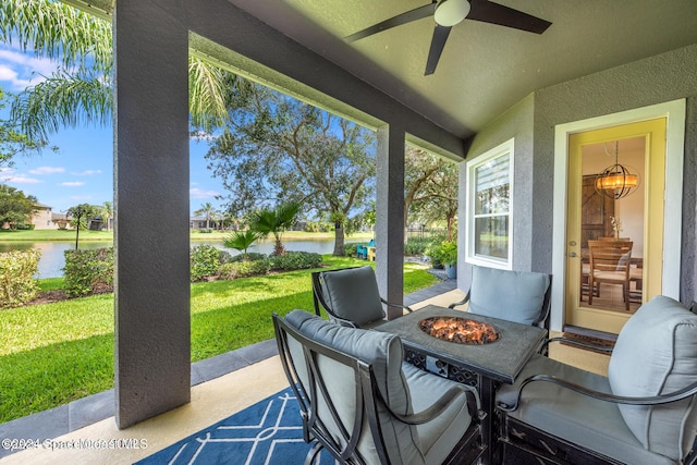 view of patio / terrace with a water view, an outdoor fire pit, and ceiling fan