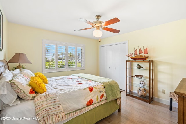 bedroom with a closet, baseboards, a ceiling fan, and wood finished floors