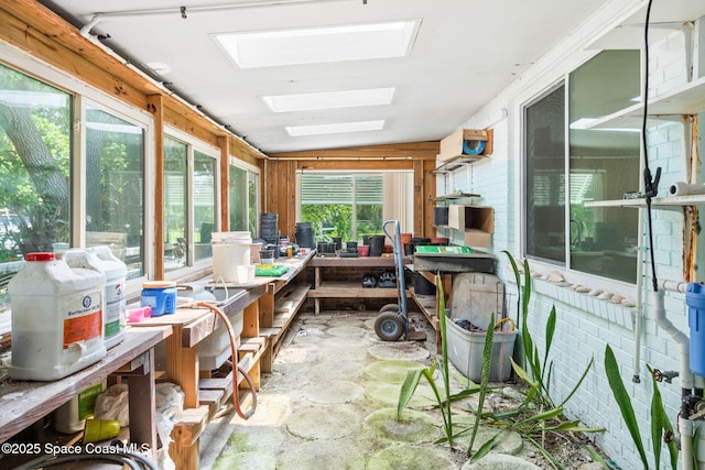 sunroom featuring a skylight and stone finish floor