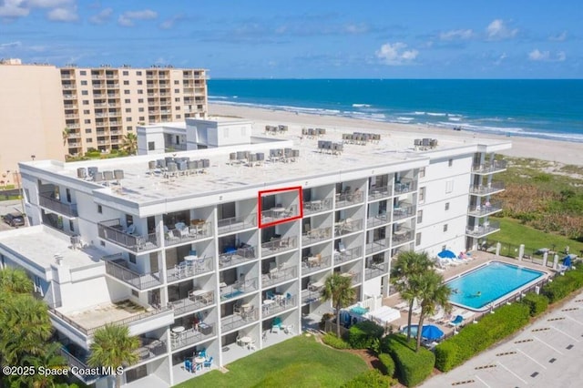 drone / aerial view with a water view and a beach view