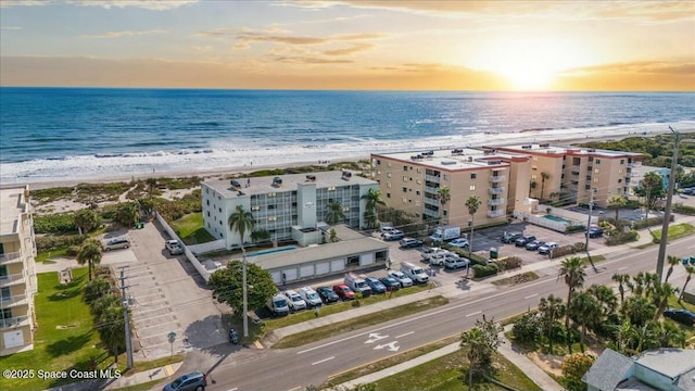 birds eye view of property with a water view and a beach view