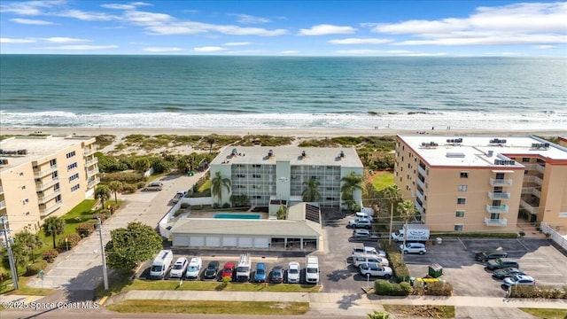 drone / aerial view featuring a water view and a beach view