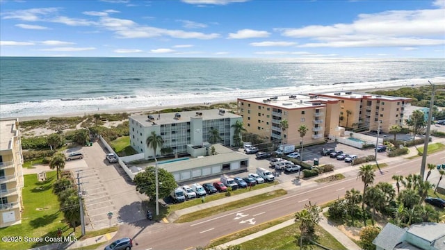 birds eye view of property with a water view and a beach view