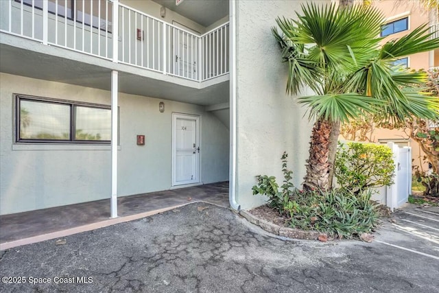 doorway to property with a balcony and stucco siding