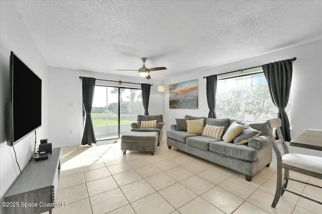 living room featuring light tile patterned floors, ceiling fan, and a textured ceiling